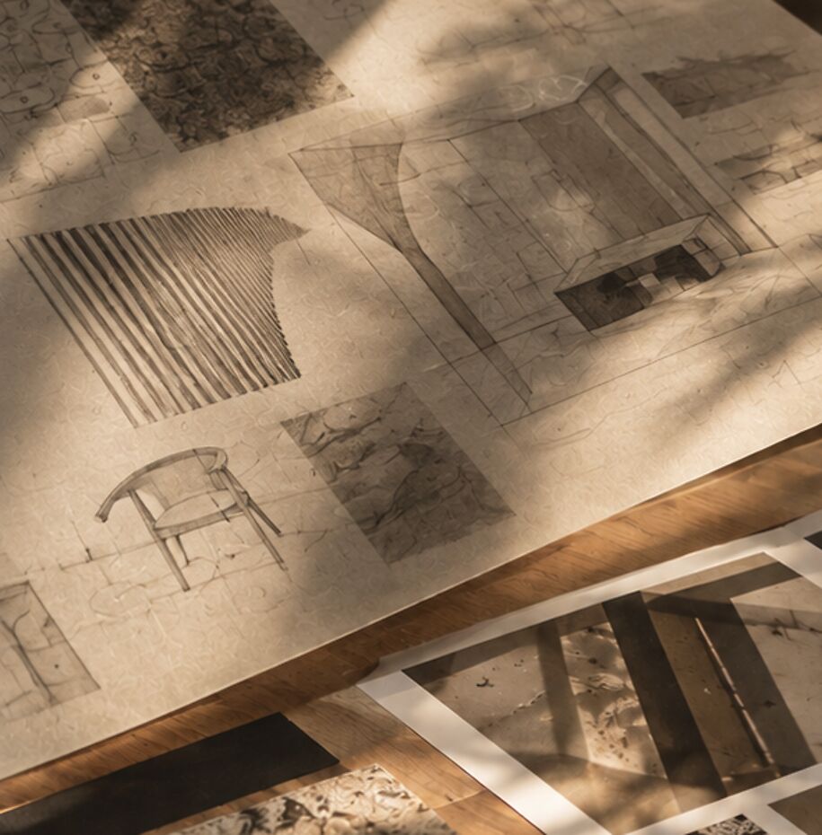 Drawings of furniture and interiors on a table in afternoon light